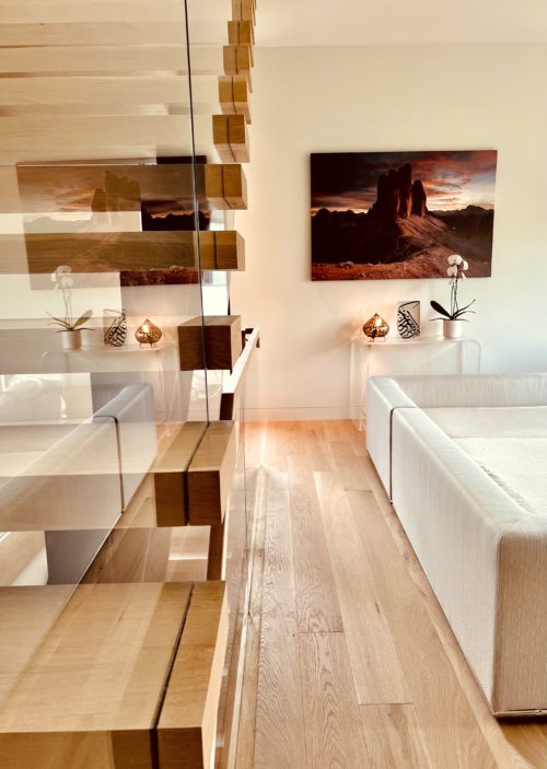 Modern living room and floating stairs with picture print and plants scaled