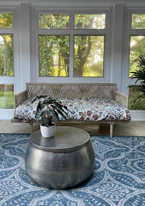 Living room with round grey coffee table and beautiful forest backdrop