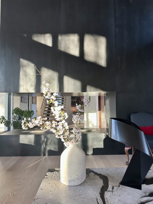 Pink flowers in a vase surrounded by a modern living room